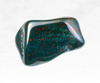 An image showcasing a bloodstone crystal chunk, displaying a deep green color interspersed with vivid red specks. The rugged texture and earthy tones of the crystal evoke a sense of grounding and vitality.