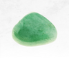 An enchanting image of a green aventurine crystal chunk, featuring a lustrous green color with a smooth and polished surface. The crystal's gentle shimmer and natural patterns evoke a sense of harmony and abundance, symbolizing growth and prosperity.