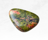 A captivating image of an unakite crystal chunk, displaying a combination of olive green and salmon pink hues. The crystal's mottled appearance and earthy tones evoke a sense of balance, grounding, and emotional healing.